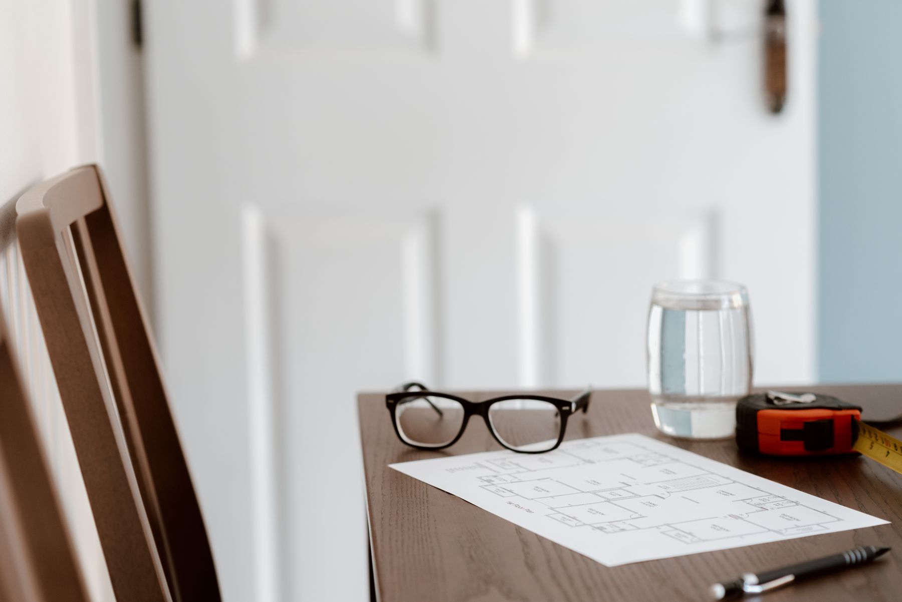 Reading glasses and a floor plan on a desk